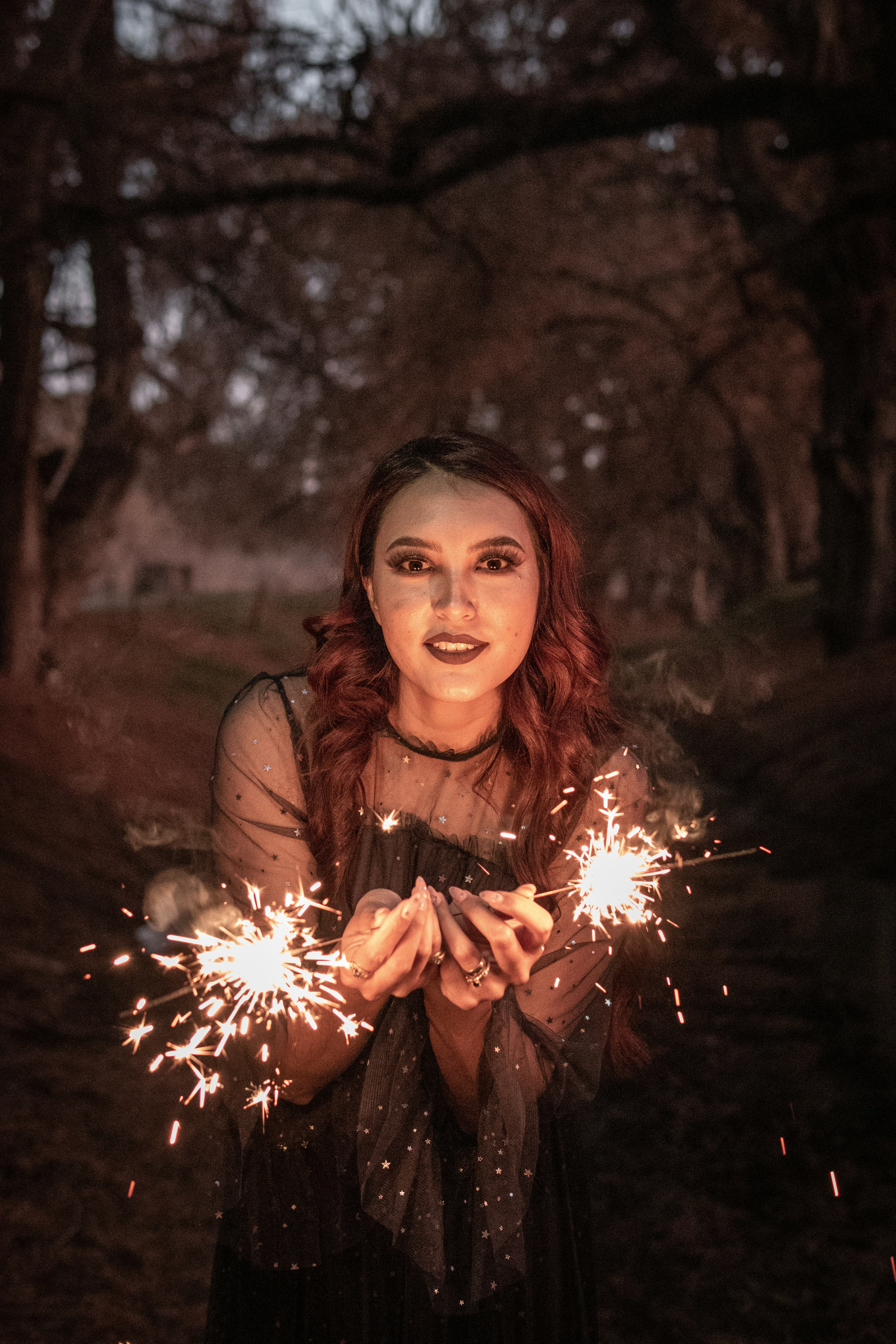 woman in brown long sleeve shirt holding sparkler